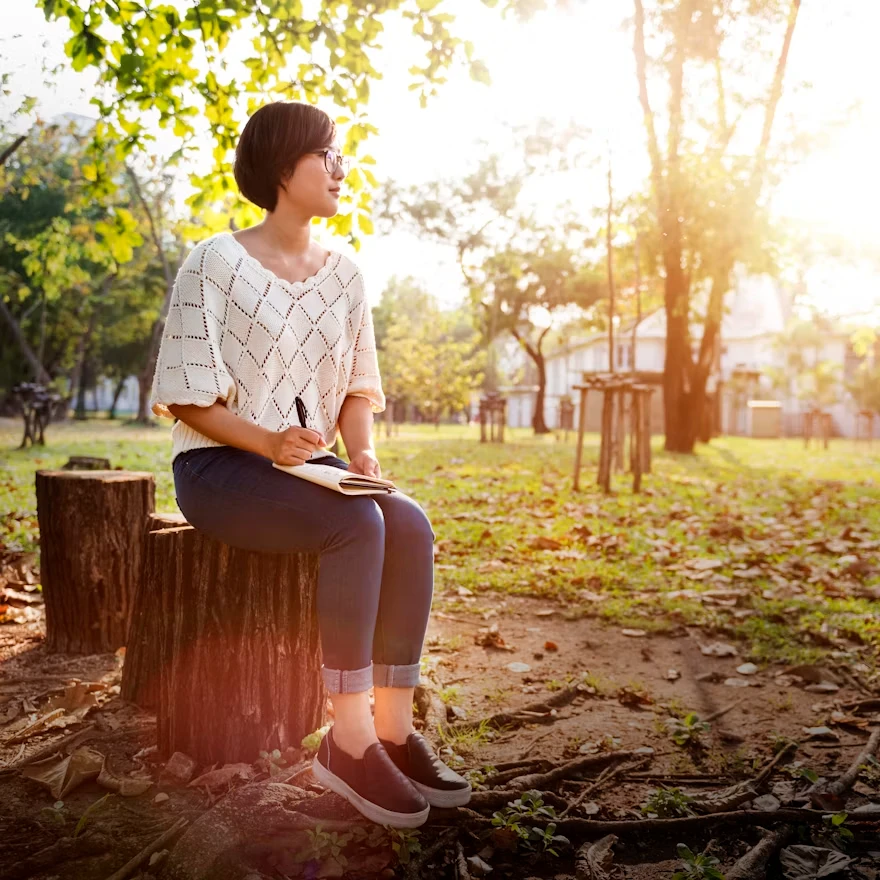 Person journaling outdoors as part of healing from trauma
